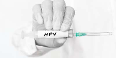 Mediziner hält HPV Spritze in der Hand