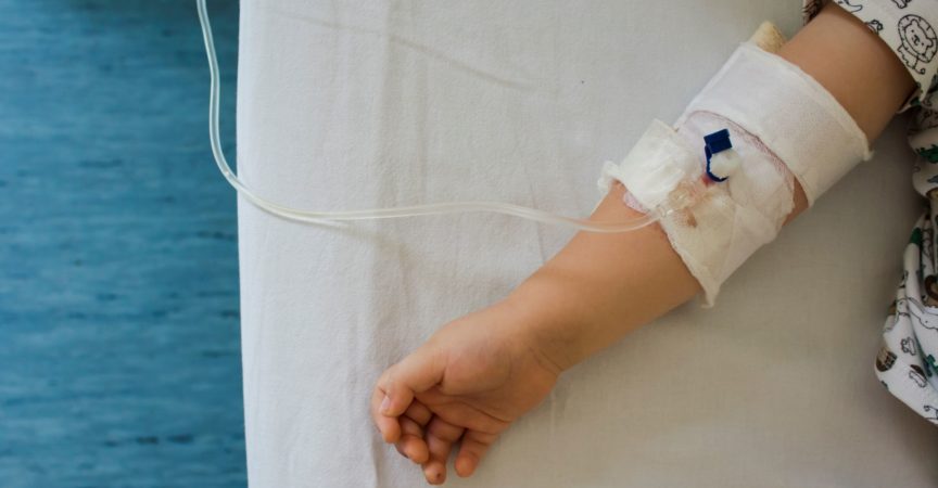 Das Kind erhält Medikamente durch intravenöse (IV) Flüssigkeitstherapie im Krankenhausbett. Erholung, Gesundheitskonzept.