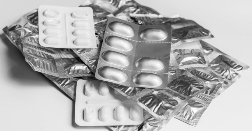 Blisterpackungen von Medizin-Tabletten in einem Stapel, auf einem einfachen Hintergrund