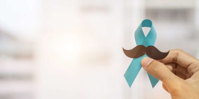 November Prostatakrebs-Bewusstseinsmonat, Mann, der blaues Band mit Schnurrbart hält, um lebende Menschen und Krankheit zu unterstützen. Gesundheitswesen, internationale Männer, Vater und Weltkrebstag Konzept