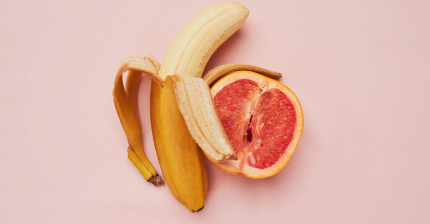Studioaufnahme einer Banane und einer Grapefruit in einer suggestiven Position vor einem rosa Hintergrund
