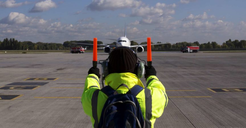 Ein Vorgesetzter hilft beim Flugzeugparken am Flughafen