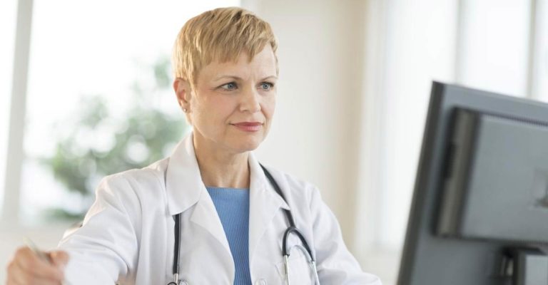 Arzt Arbeiten am Computer am Schreibtisch