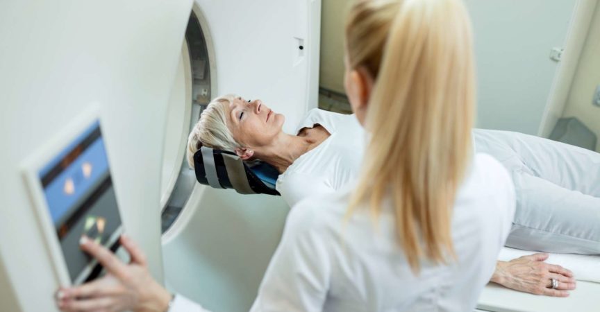 High Angle View der reifen Frau und des Radiologen während der MRT-Untersuchung in der Klinik.