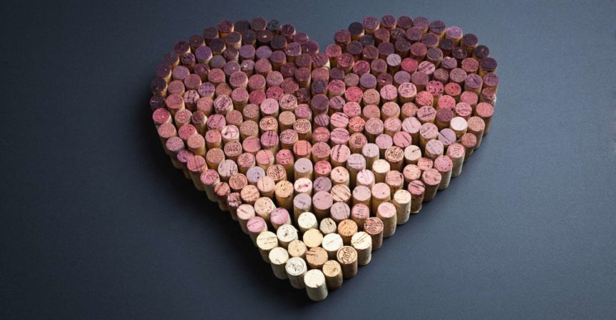 Weinkorken in Herzform auf grauem Hintergrund angeordnet