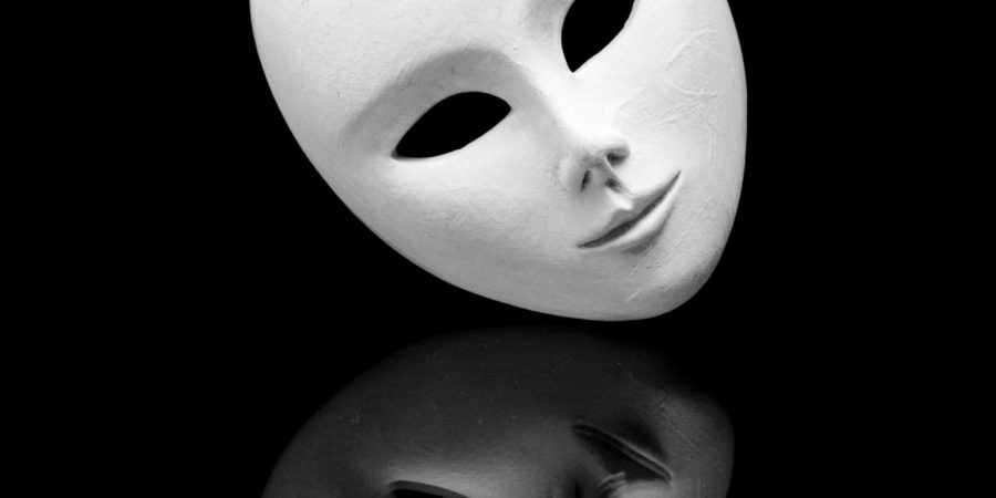 weiße teilnahmslose venezianische Maske und ihre Reflexion im schwarzen Spiegel