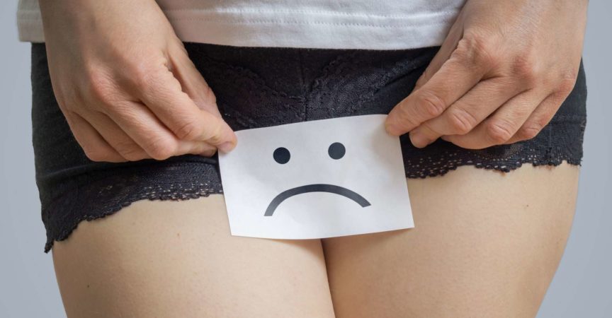 Konzept für vaginale oder menstruelle Probleme. Junge Frau hält Papier mit SOS über Schritt.