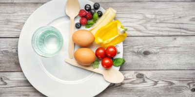 Intervall-Fasten-Diät-Konzept mit einem Teller und Produkten dargestellt