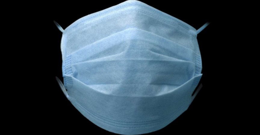 Schützende Gesichtsmaske auf farbigem Hintergrund. Farbe Hartfaserplatte