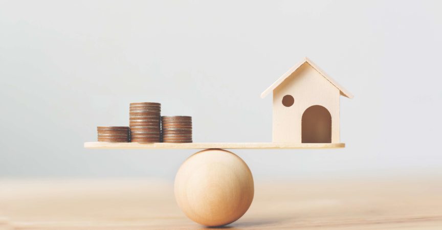 Haus- und Geldmünzen aus Holz stapeln sich auf Holzschuppen. Immobilieninvestment und Haushypothek Finanzimmobilienkonzept
