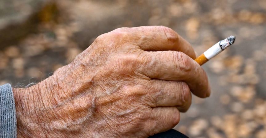 Hand eines sehr alten Mannes mit Zigarette