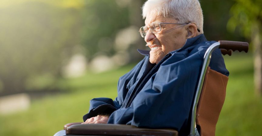 Ein 92 Jahre alter Mann sitzt in seinem Rollstuhl und genießt die Abendsonne.