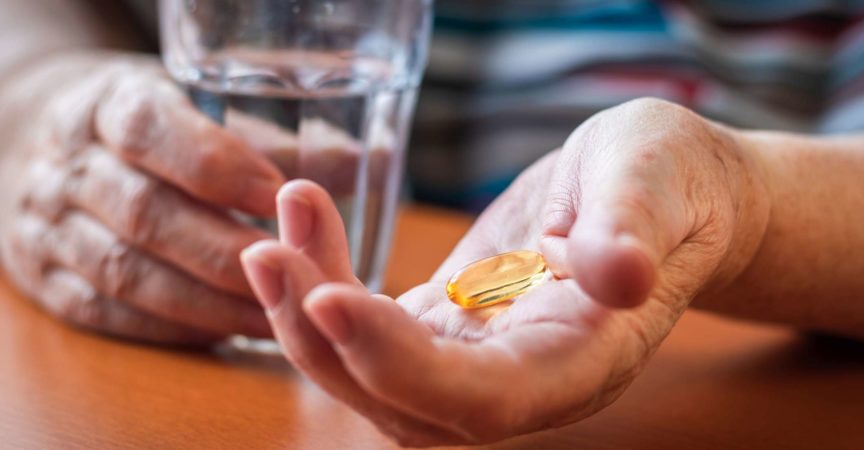 Omega-3-Pille und Glas Wasser in älteren weiblichen Händen. Medizin- und Gesundheitskonzept mit Menschen