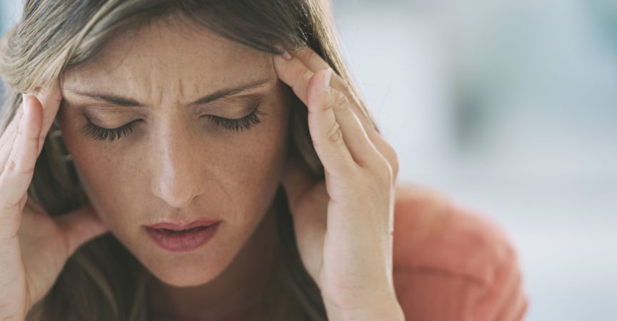 Aufnahme einer attraktiven jungen Frau, die zu Hause unter starken Kopfschmerzen leidet