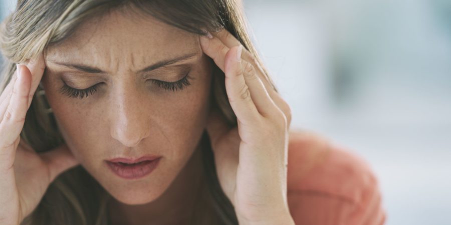 Aufnahme einer attraktiven jungen Frau, die zu Hause unter starken Kopfschmerzen leidet