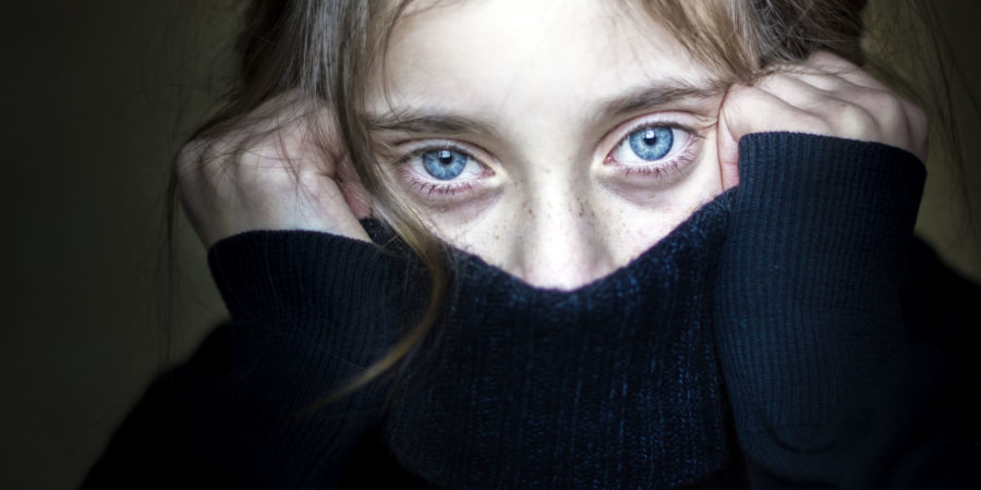 Besorgtes und verängstigtes Mädchen, das ihr Gesicht versteckt