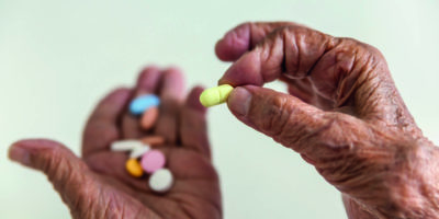 Nahaufnahme von senior Frau Hand Pille pflücken