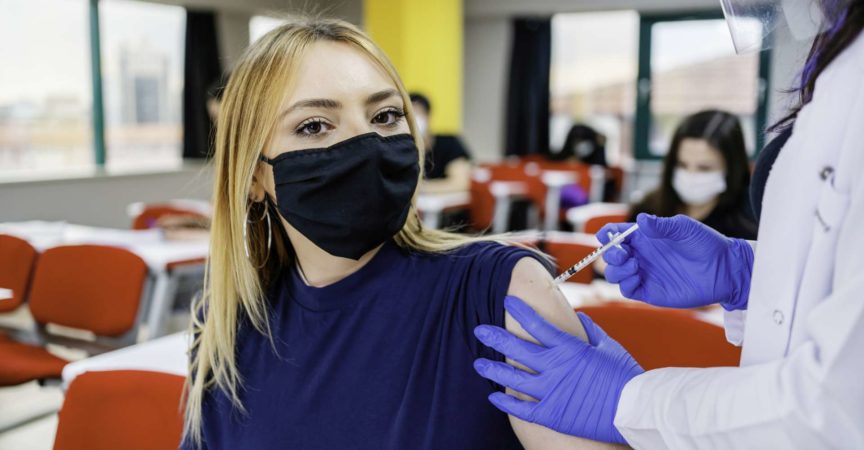 Krankenschwester gibt Schülern während der Coronavirus-Pandemie eine Impfung in der Schule
