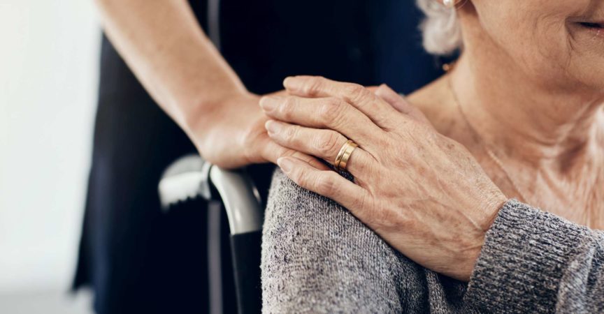 Abgeschnittene Aufnahme einer weiblichen Pflegekraft, die eine ältere Frau tröstet
