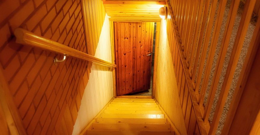 Eine Holztreppe im Haus führt hinunter zur Tür