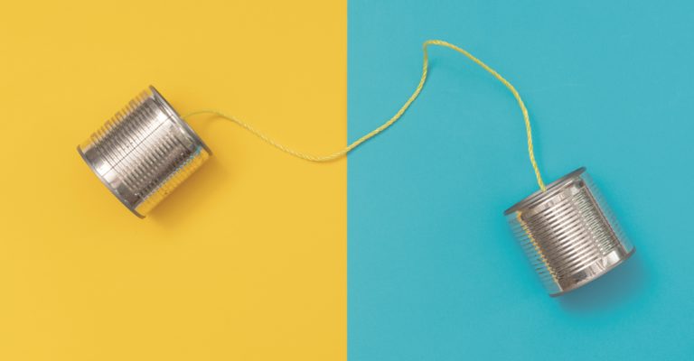 Blechdose auf gelbem und blauem Papierhintergrund telefonieren