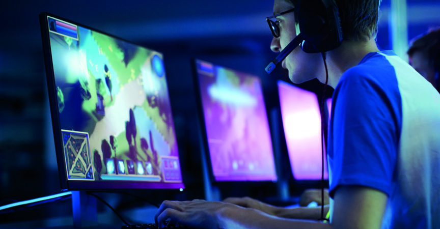 Team von professionellen eSport-Gamern, die in einem kompetitiven MMORPG/Strategie-Videospiel auf einem Cyber-Games-Turnier spielen. Sie sprechen miteinander in Mikrofone. Arena sieht cool aus mit Neonlichtern.