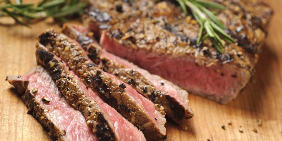 Gegrilltes Steak wird auf einem Schneidebrett in Scheiben geschnitten. Bitte sehen Sie mein Portfolio für andere lebensmittelbezogene Bilder.