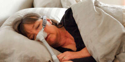 Ältere Frau mit Beatmungsmaske am schlafen