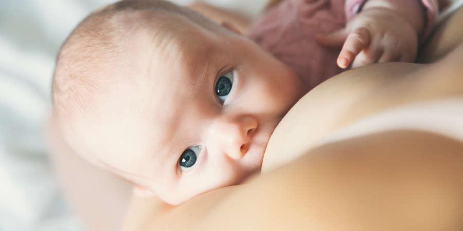Baby eating mother’s milk. Mother breastfeeding baby.