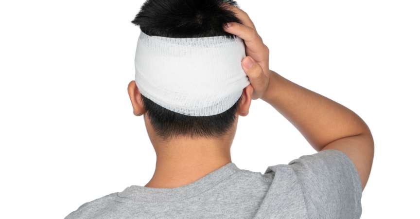 Kopfschuss unglücklicher Nahaufnahme Asiatischer Junge, der mit geschlossenen Augen an Kopfschmerzen leidet und den Kopf berührt. Kranker Junge, der mit einem kühlen Gelee auf seinem Kopf liegt.