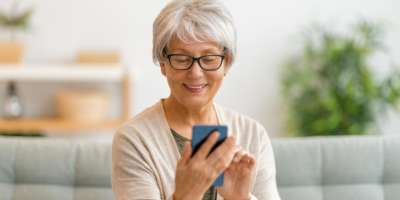 Seniorin benützt ihr Smartphone