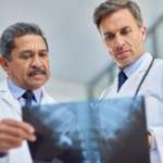 Schnappschuss von zwei Ärzten, die sich gemeinsam ein Röntgenbild ansehen