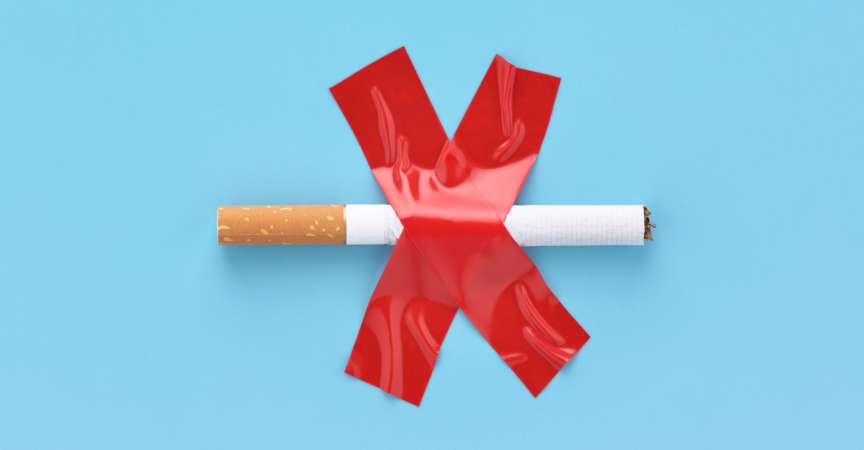 Durchgestrichene Zigarette, mit rotem Klebeband auf blauem Grund aufgeklebt. Nichtraucherkonzept.