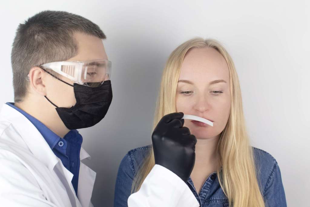 Das Mädchen klagt beim Arzt über den Geruchsverlust. Der Arzt führt einen Geruchstest durch. Diagnose von Covid-19. Symptome des Coronavirus. Quarantäne und Isolation. Test auf sars-cov-2