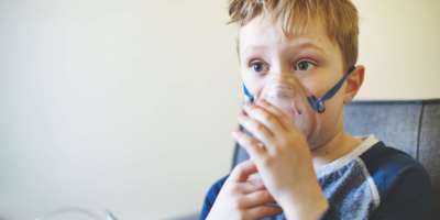 Kind mit Asthma-Inhalator zu Hause