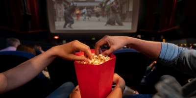 Nahaufnahme eines Paares im Kino, das Popcorn isst - Unterhaltungskonzepte. **BILD AUF DEM BILDSCHIRM GEHÖRT UNS**