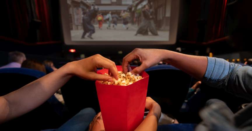 Nahaufnahme eines Paares im Kino, das Popcorn isst - Unterhaltungskonzepte. **BILD AUF DEM BILDSCHIRM GEHÖRT UNS**