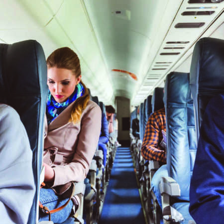Innenraum des Flugzeugs mit Menschen, die auf Sitzen sitzen. Passagiere auf Sitzplätzen während des Fluges.