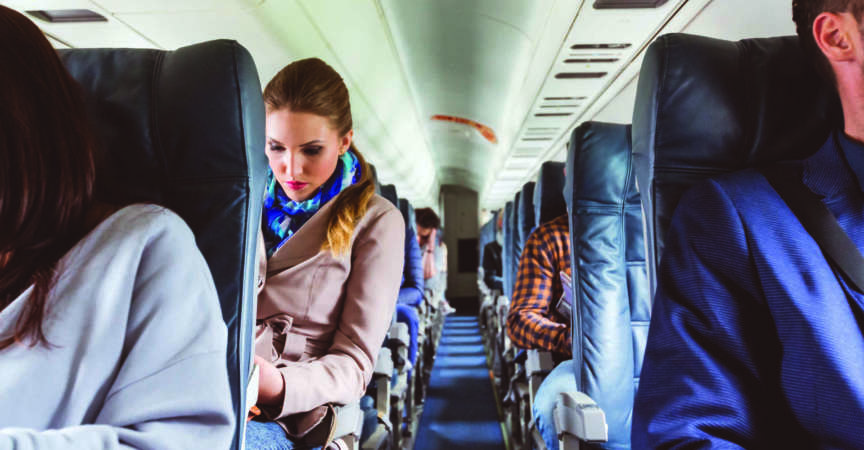 Innenraum des Flugzeugs mit Menschen, die auf Sitzen sitzen. Passagiere auf Sitzplätzen während des Fluges.