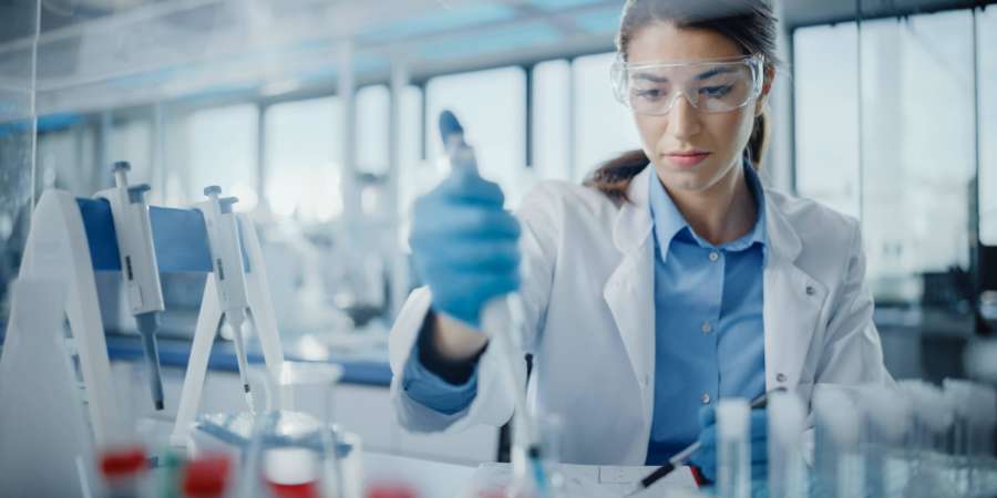 Medizinisches Forschungslabor: Porträt einer schönen Wissenschaftlerin mit Brille, die eine Mikropipette für die Testanalyse verwendet. Fortschrittliches wissenschaftliches Labor für Medizin, Biotechnologie, mikrobiologische Entwicklung