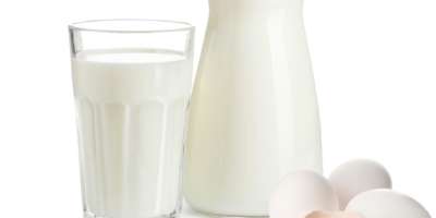 Milch im Krug und Glas sowie Eier und Erdnüsse