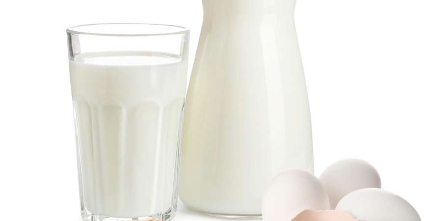 Milch im Krug und Glas sowie Eier und Erdnüsse