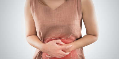 Das Foto des Dickdarms befindet sich auf dem Körper der Frau. Menschen mit Magenschmerzen-Problem-Konzept. Weibliche Anatomie