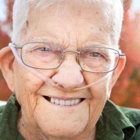Eine Nahaufnahme eines hübschen 92-jährigen Mannes, der an einem schönen Herbsttag im Freien lächelt.