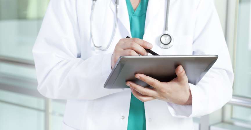 Arzt im Krankenhaus beim Schreiben digitaler Tablets