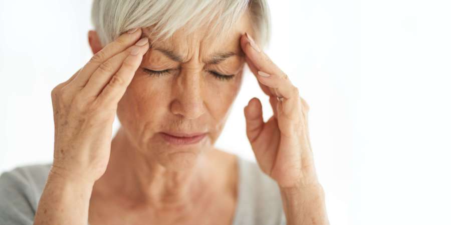Aufnahme einer älteren Frau, die zu Hause unter Kopfschmerzen leidet