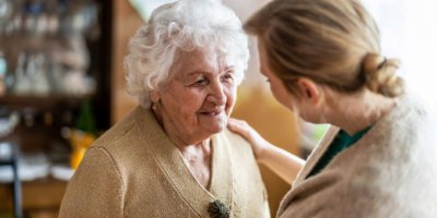 Gesundheitsbesucher im Gespräch mit einer älteren Frau während des Hausbesuchs