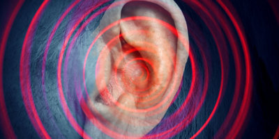 Nahaufnahme eines Ohrs mit illustrierten roten Tinnitus-Schallwellen