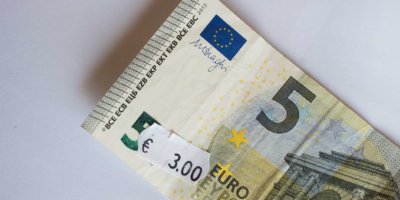 Fünf-Euro-Banknote mit drei Euro Preisschild. Selektiver Fokus auf Label.