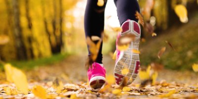 Nahaufnahme von Läuferfüßen, die im Herbst laufen, lässt Trainingsübung